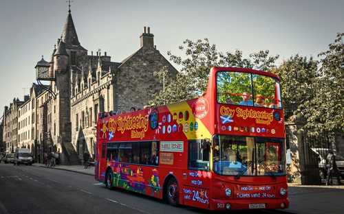 Autobús descapotable frente al Castillo de Edimburgo